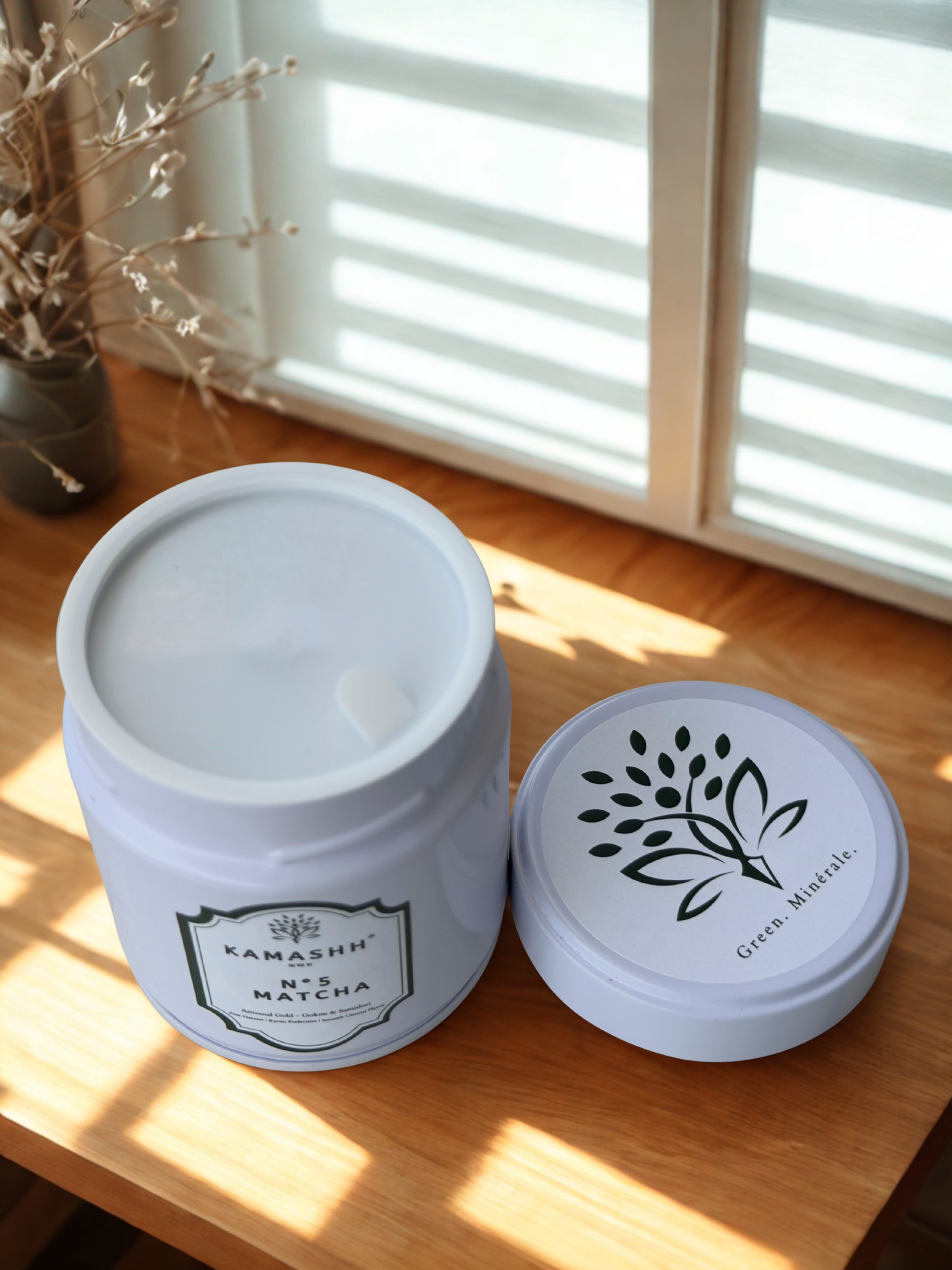 Premium Japanese ceremonial matcha in white tin styled in a minimalist tea setting. Shop kamashh India