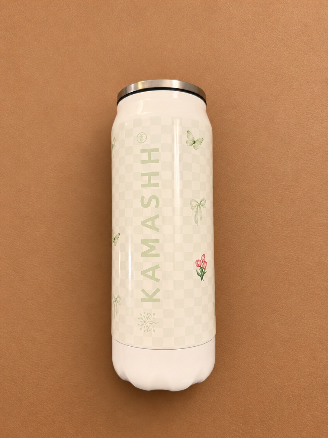 Kamashh India Fiora floral metal can coffee sipper with a metal-rimmed lid, standing against a beige background